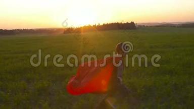 日落时穿着超级英雄斗篷的男孩在田野里奔跑